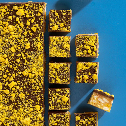 Brownies with yellow crumb topping arranged on a blue background