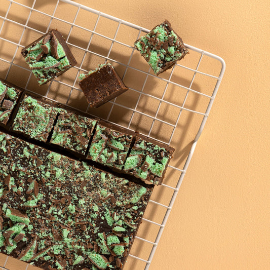 Mint chocolate brownies on a cooling rack with a beige background