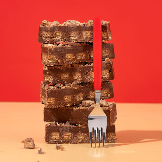 Stack of chocolate bars with a fork against a red background
